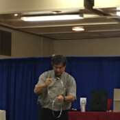 Marty G performing magic trick with three large metal rings.
