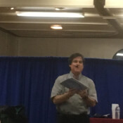 Marty G iperforming magic trick involving oversize playing cards.